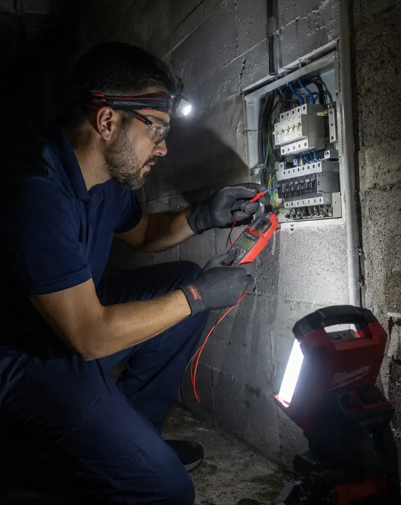 Instalador autorizado revisando cuadro eléctrico de noche