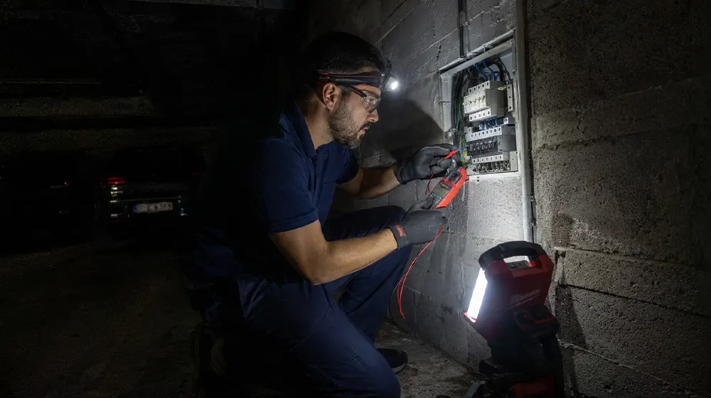 Instalador autorizado revisando cuadro eléctrico de noche